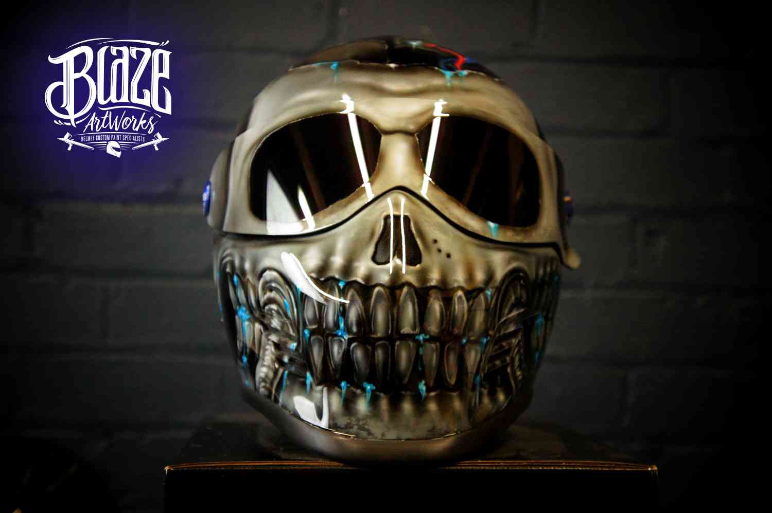 Chrome skull motorcycle helmet with metallic silver finish, detailed teeth and jaw, dark eye sockets, professional airbrush work